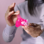 Person holding pink heart shaped ornament
