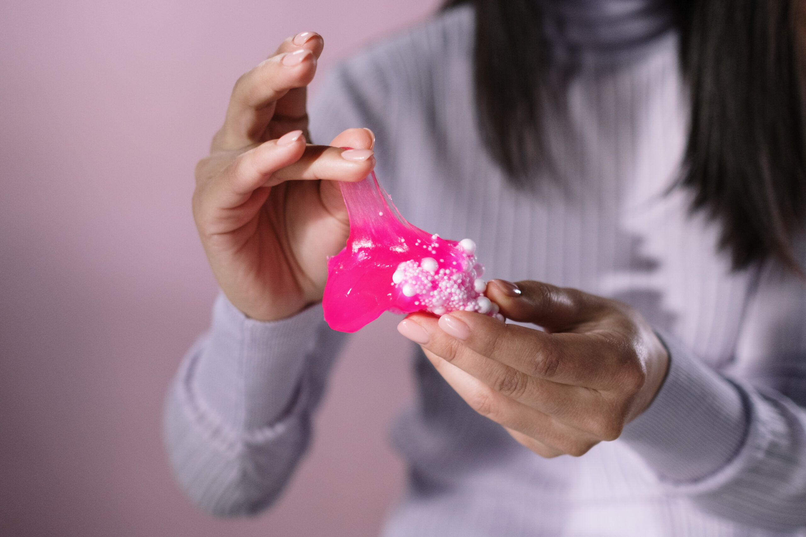 Person holding pink heart shaped ornament